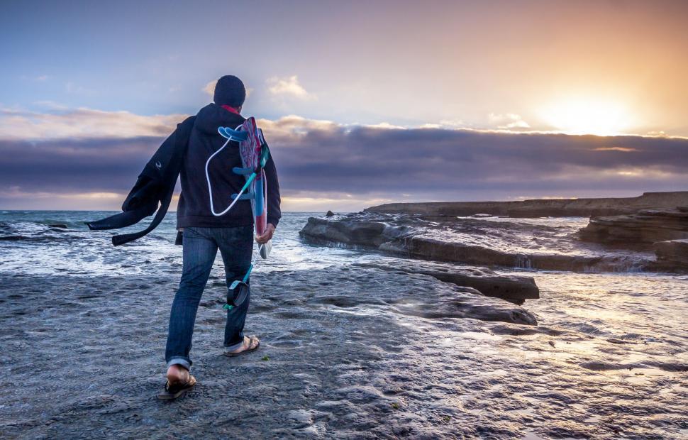 Free Image of Man Walking on Beach With Surfboard 