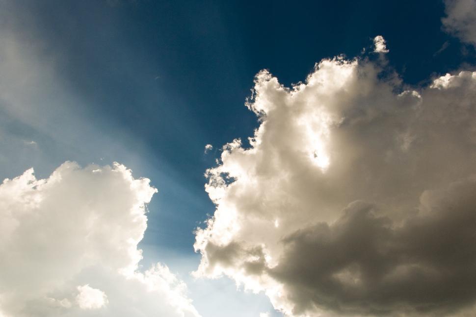 Free Image of Plane Flying Through Cloudy Blue Sky 