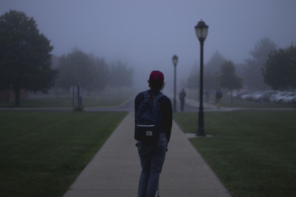 Free Image of Man Walking Down Sidewalk in Rain 
