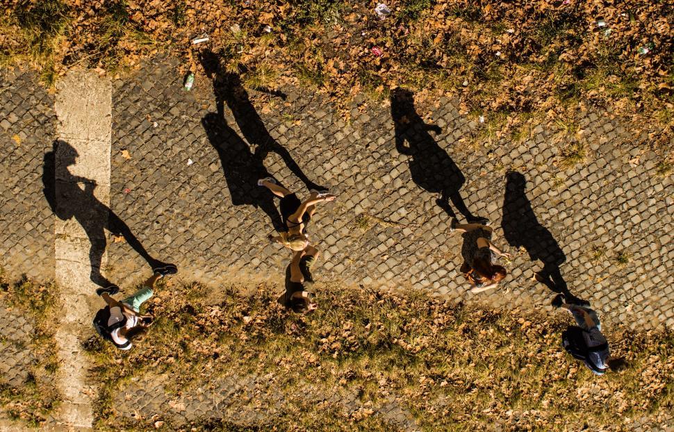 Free Image of Group of People Walking Down a Sidewalk 