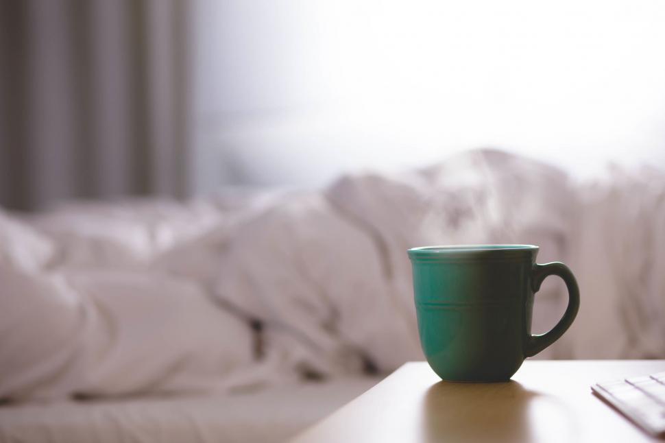 Free Image of Coffee Cup Next to Laptop on Table 