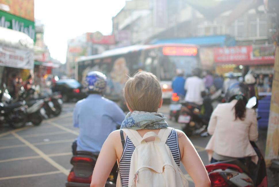 Free Image of Woman Walking Down Street With Backpack 