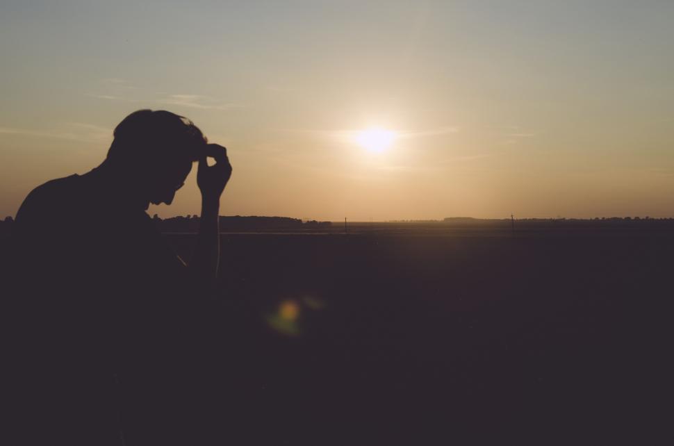 Free Image of Man Holding Microphone in Front of the Sun 