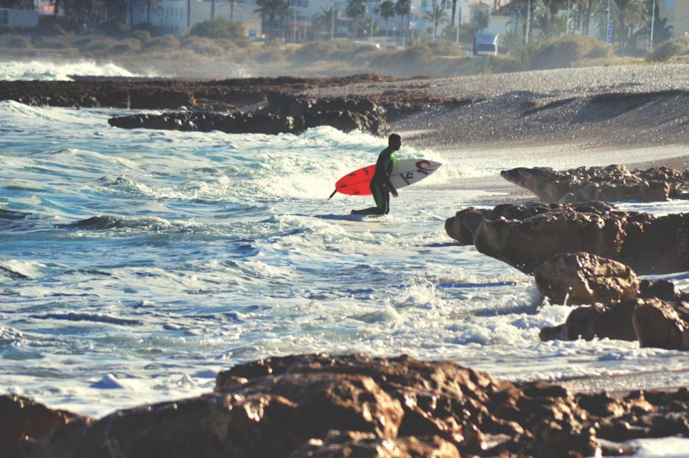 Free Image of Man Walking Into Ocean With Surfboard 