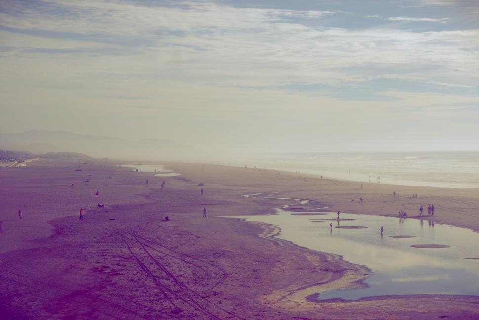 Free Image of Group of People Standing on Beach by Water 