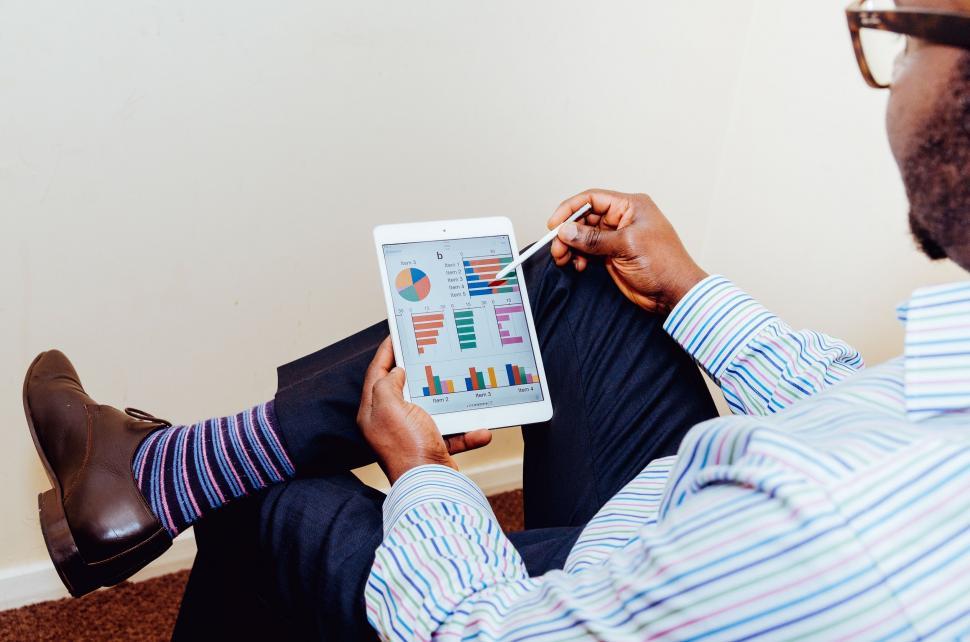 Free Image of Man Sitting on the Floor Holding a Tablet 