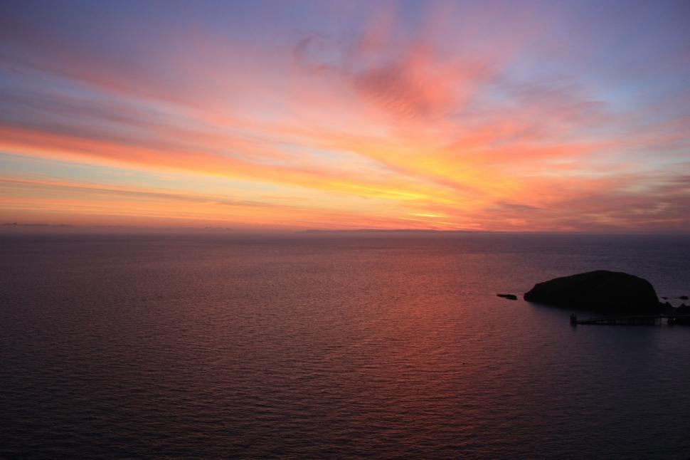 Free Image of Sunset Over Body of Water With Small Island 