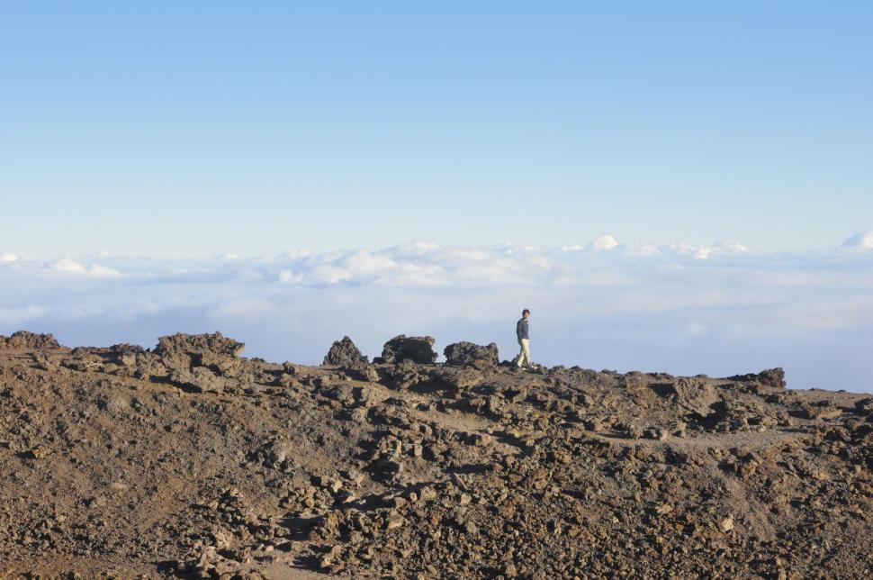 Free Image of Man Standing on Top of Rocky Hill 