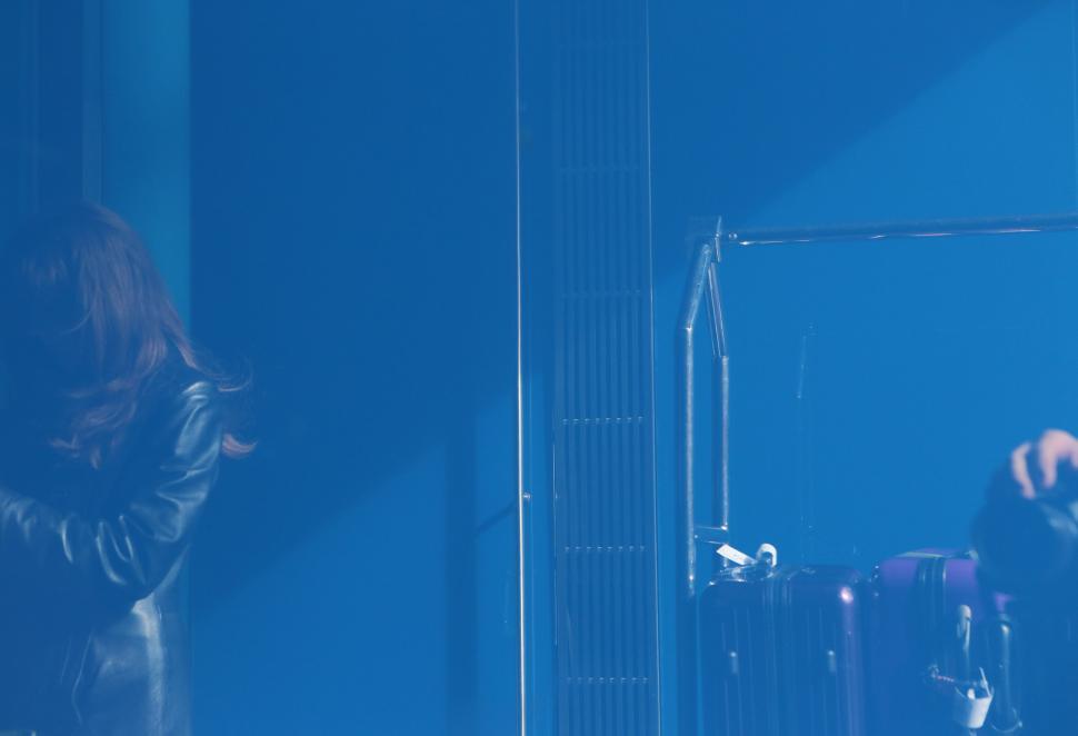 Free Image of Woman Standing in Front of Mirror in Room 