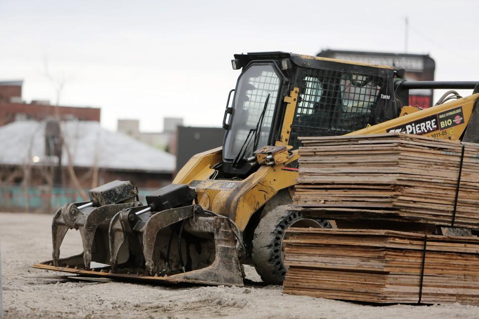 Free Image of Bulldozer Parked on Pile of Wood 