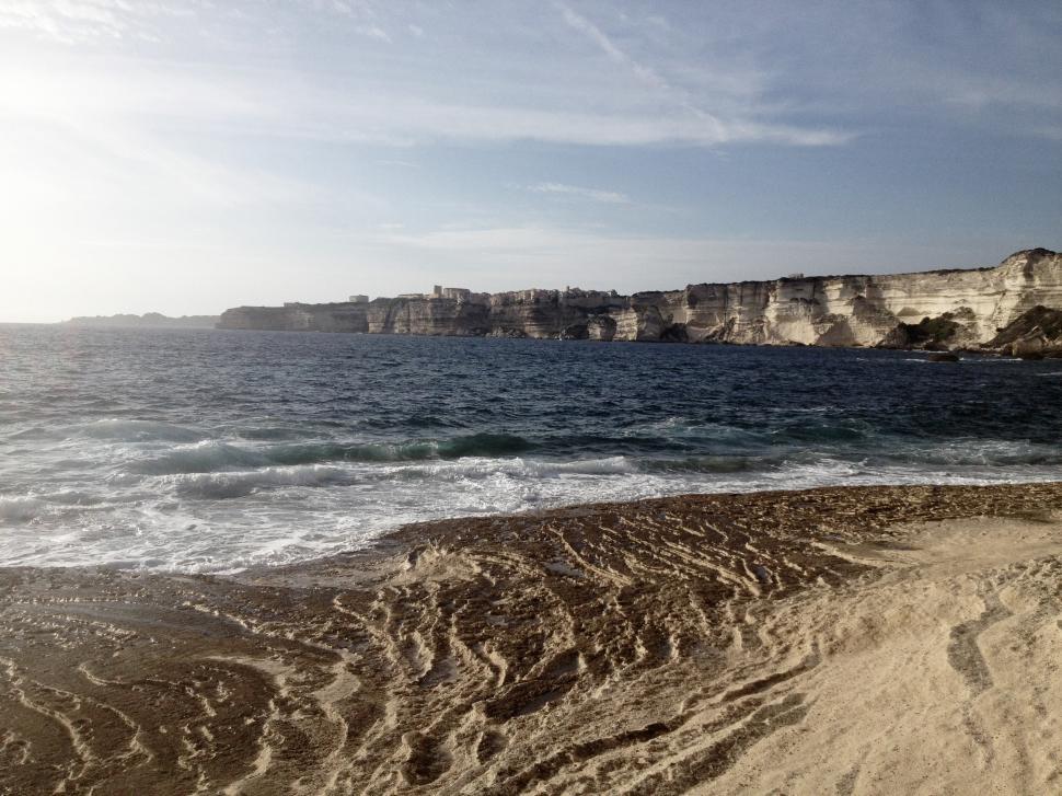 Free Image of Sandy Beach Next to Body of Water 