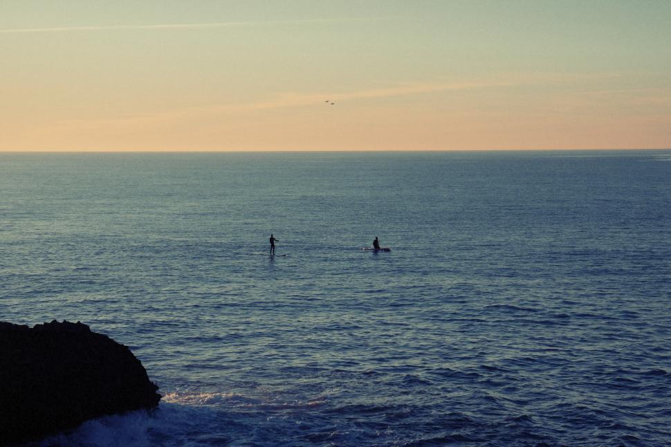 Free Image of People Standing on Top of a Large Body of Water 