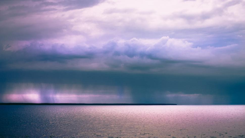 Free Image of Cloudy Sky Over Large Body of Water 