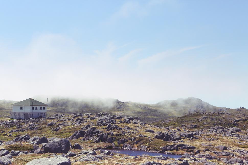 Free Image of House Perched on Rocky Hill With Stream 
