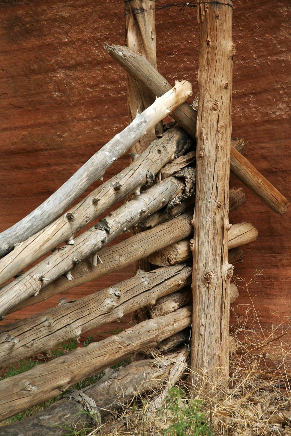 Free Stock Photo of Wooden Fence of Logs in Front of Brown Wall ...