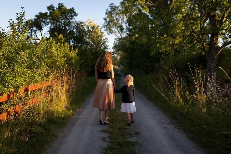 Free Image of Woman and Child Walking Down Dirt Road 