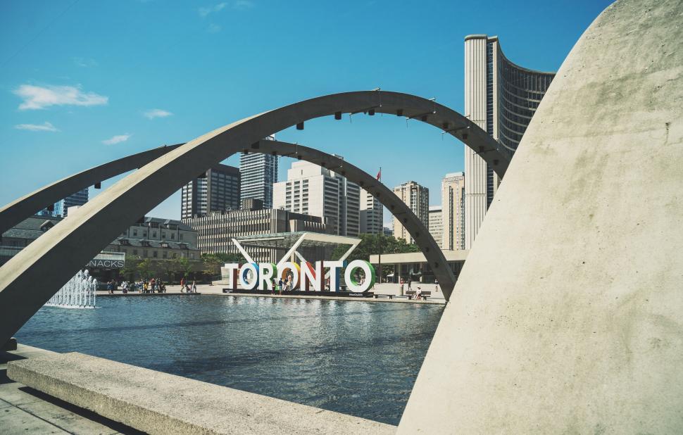 Free Image of Majestic Arch Spanning Body of Water With City Background 