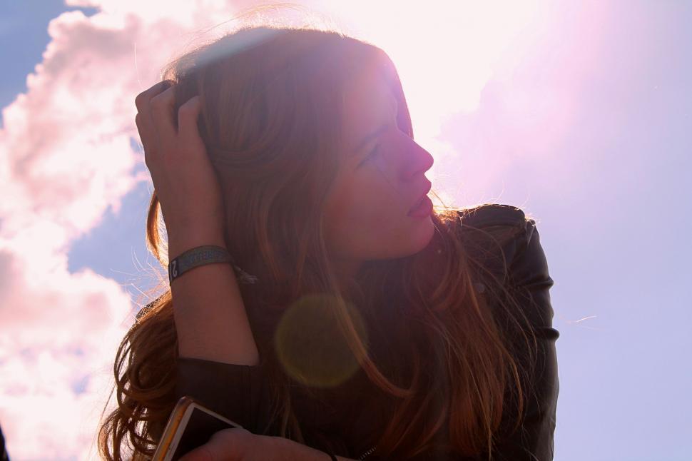 Free Image of Woman Standing in Front of Cloudy Sky 