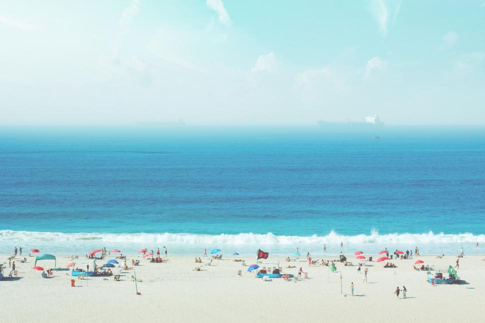 Free Image of Group of People Standing on Top of Sandy Beach 