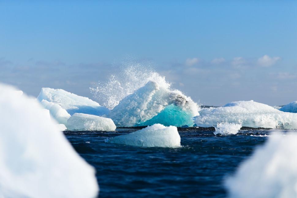 Free Image of Icebergs Floating in the Ocean With Blue Sky Background 