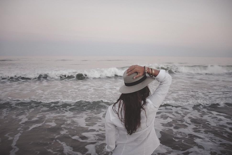 Free Image of Woman Standing on Beach Next to Ocean 