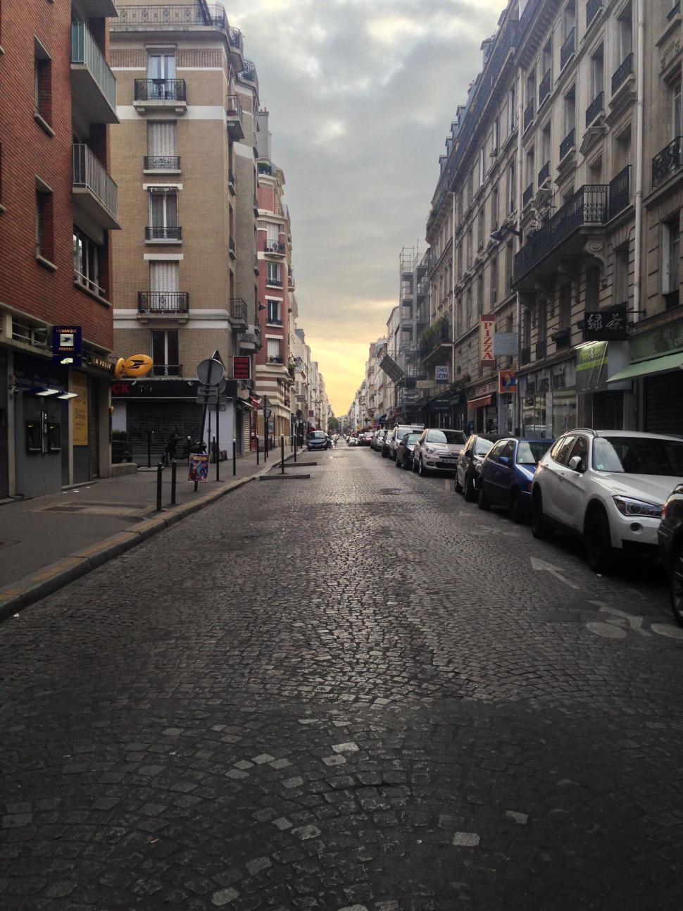 Free Image of Urban Street With Parked Cars and Tall Buildings 