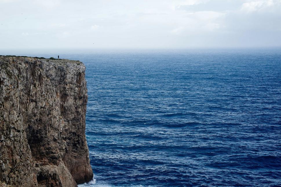 Free Image of Person Standing on Cliff Overlooking Ocean 