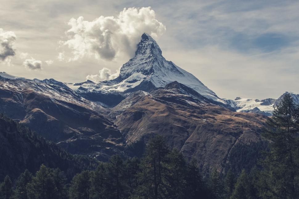 Free Image of Snow Covered Mountain With Trees in Foreground 