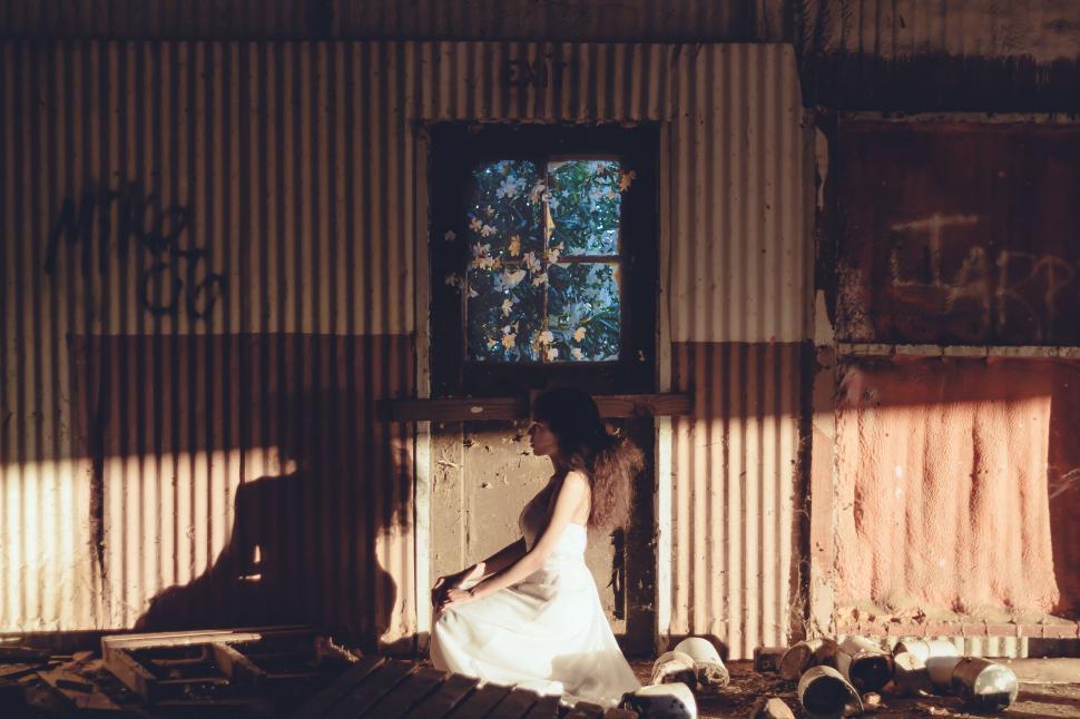 Free Image of Woman in White Dress Standing in Front of Building 