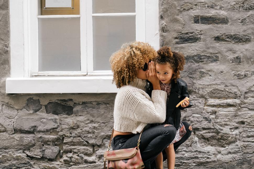 Free Image of Woman and Child Sitting on Bench in Front of Window 