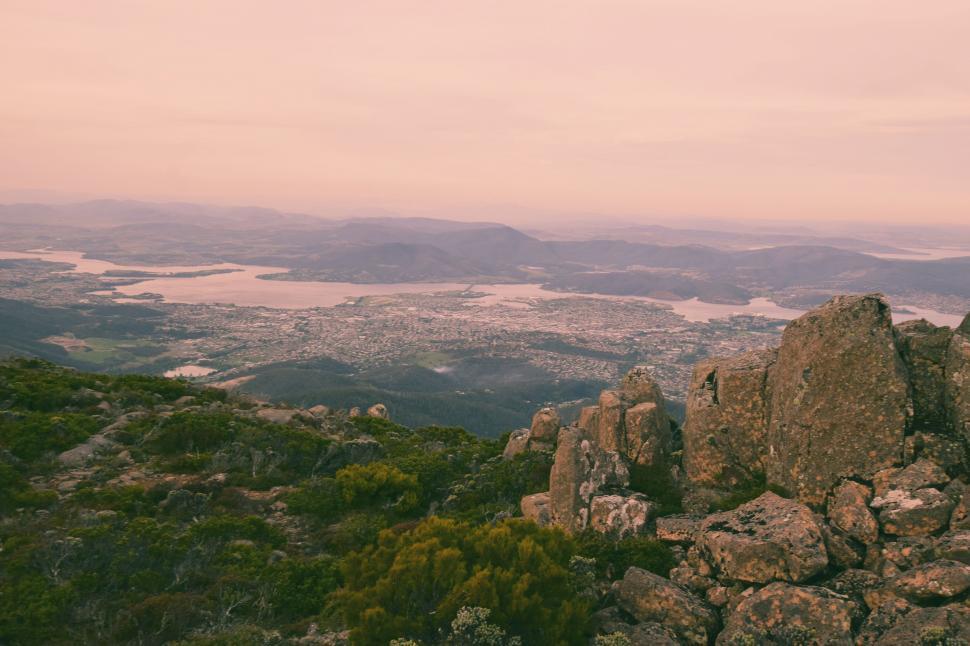 Free Image of Man Standing on Top of Mountain Next to Lush Green Forest 