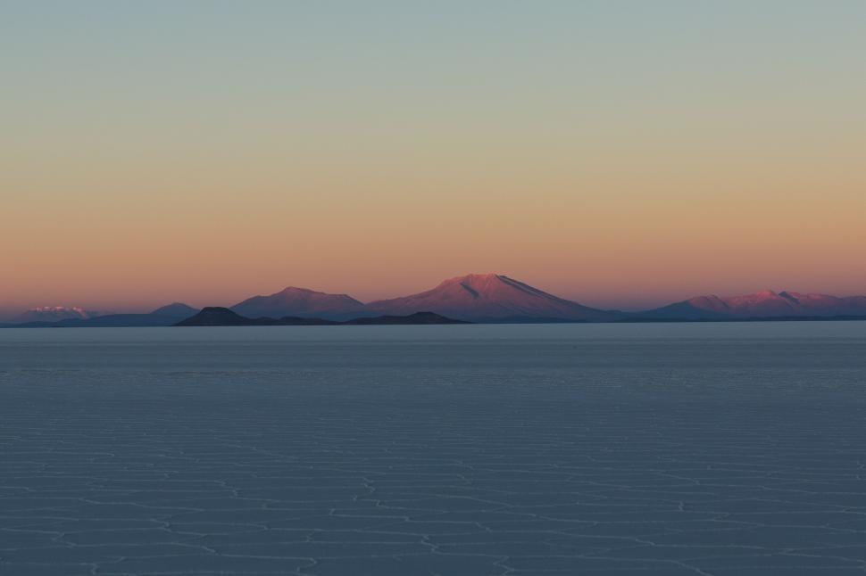 Free Image of Majestic Mountains Towering Over Vast Body of Water 