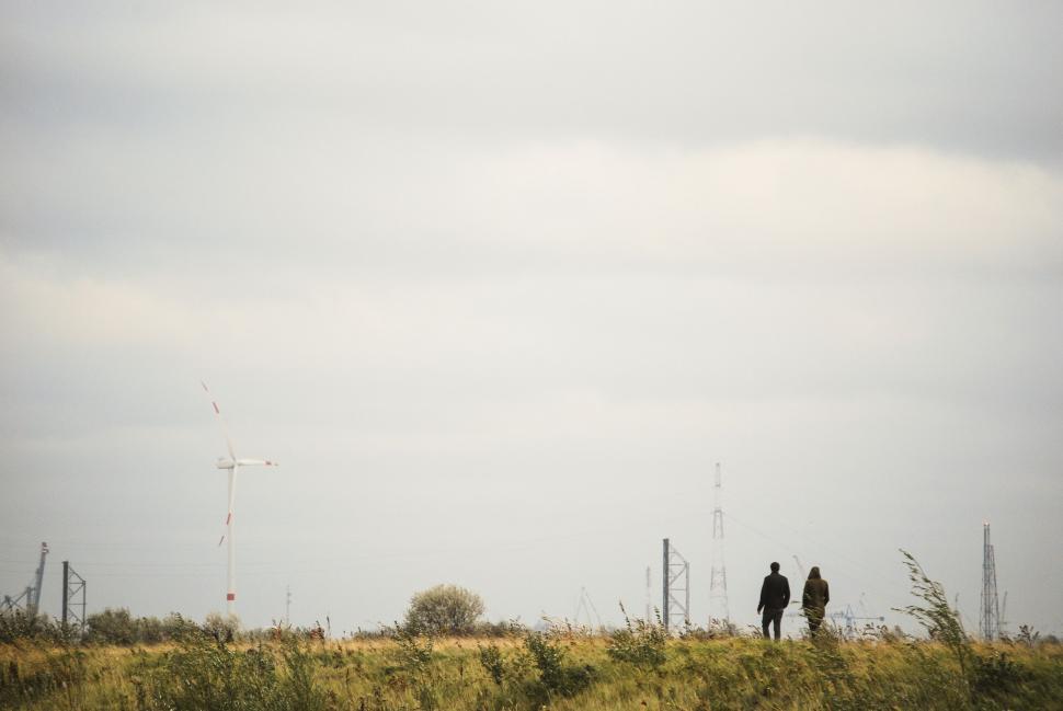 Free Image of Couple Standing on Top of Grass Covered Field 