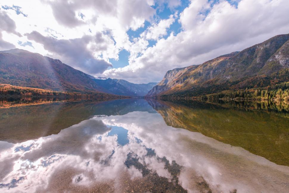 Free Image of Majestic Mountains Surrounding Water Body Under Cloudy Sky 