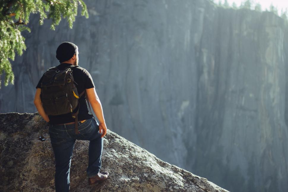 Free Image of Man Sitting on Top of a Large Rock 