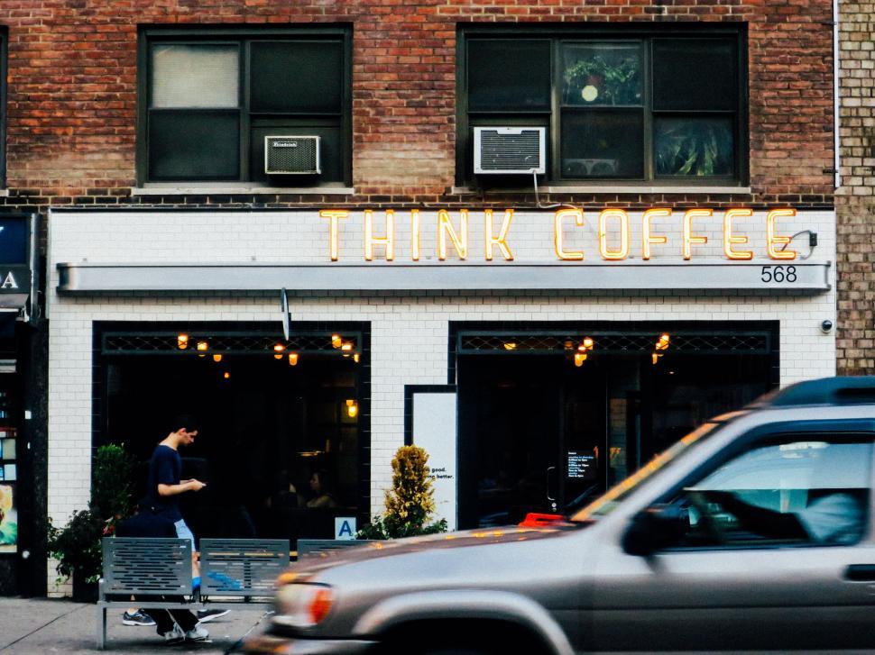Free Image of Man Riding Skateboard Down Street Next to Building 