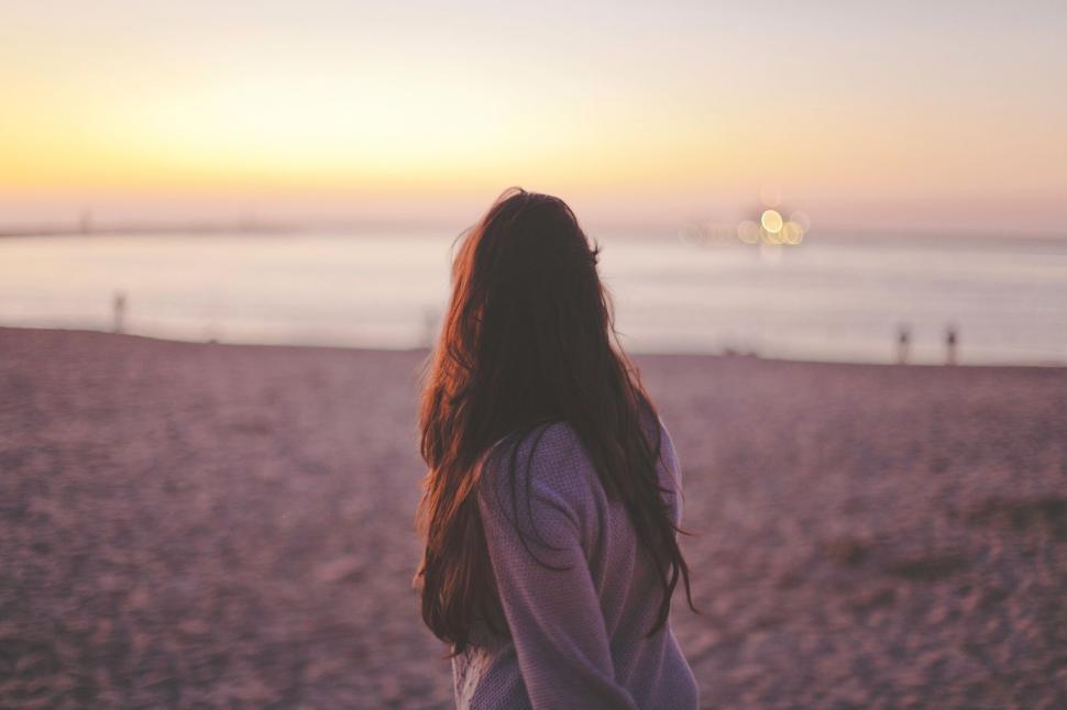 Free Image of Woman Standing on Top of Sandy Beach 