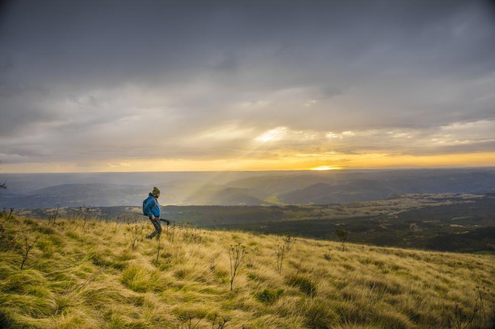 Free Image of Person Standing on Top of Grass Covered Hill 