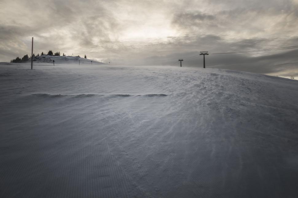 Free Image of Snow Covered Hill With Distant Power Lines 