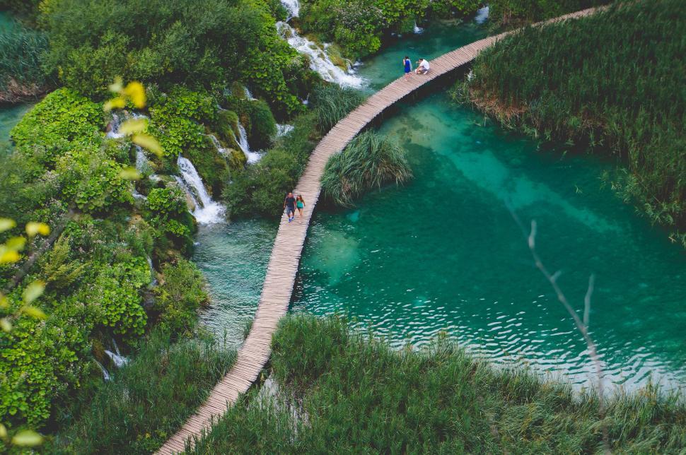 Free Image of Person Walking Across Bridge Over River 