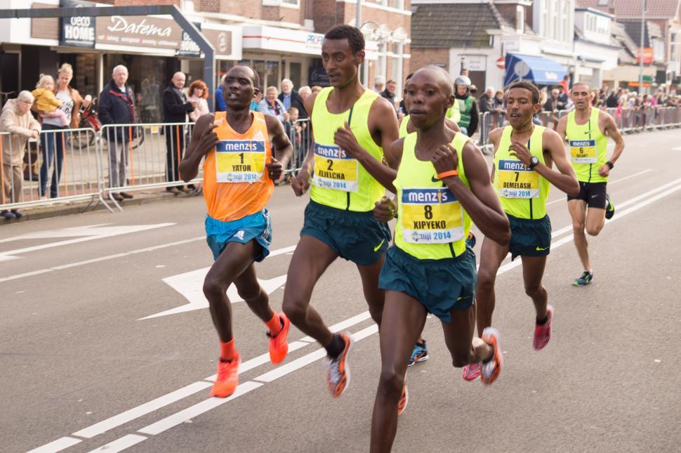 Free Image of Group of Men Running Down a Street 