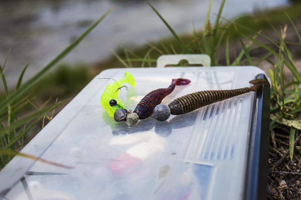 Free Stock Photo of Soft plastic lures with jig heads lie on the fishing  lure kits. Fishing on a small river from the shore