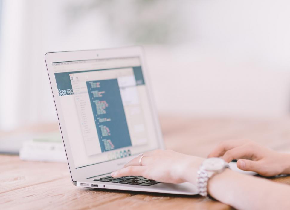 Free Image of Person Typing on Laptop on Wooden Table 