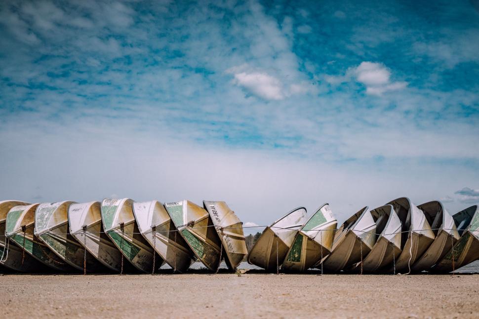 Free Image of Row of Canoes on Sandy Beach 