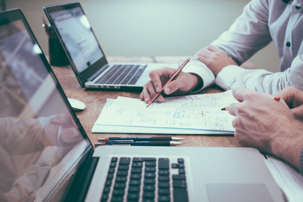 Free Image of Three People Working at Table With Laptops and Papers 