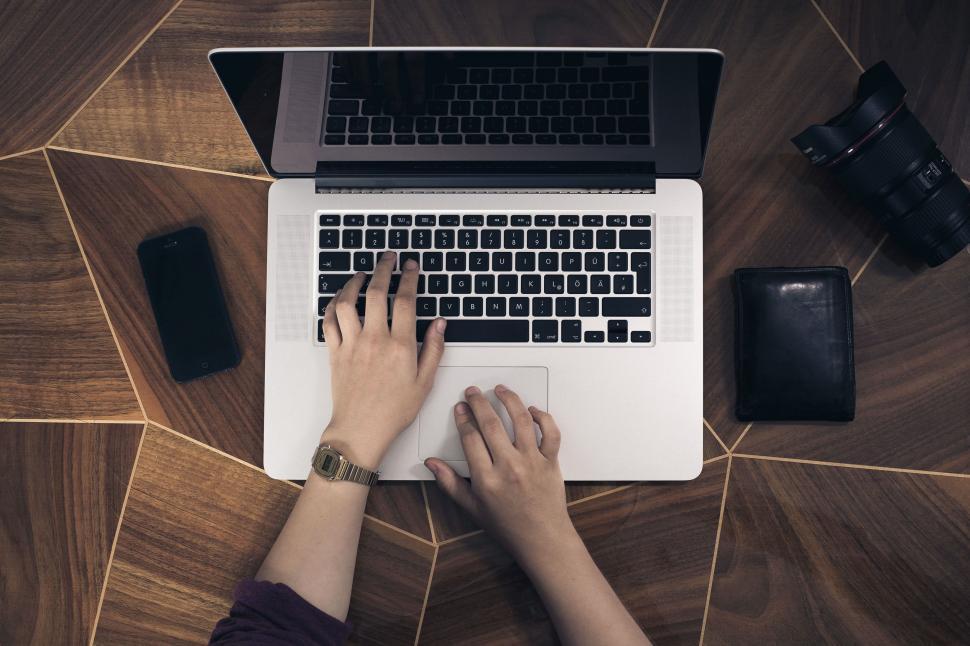 Free Image of Person Typing on Laptop on Wooden Table 