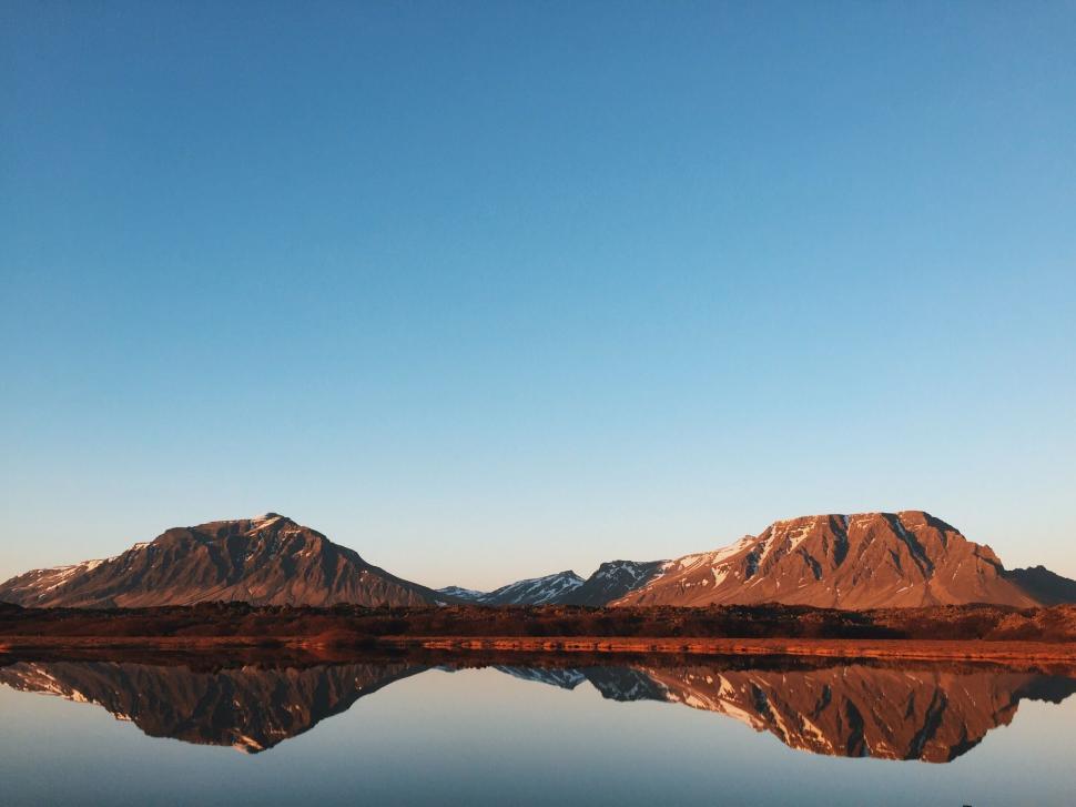 Free Image of Majestic Mountains Towering Over Vast Body of Water 