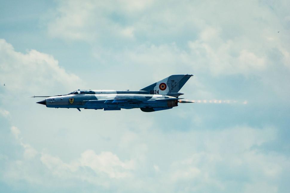 Free Image of Fighter Jet Flying Through Cloudy Blue Sky 