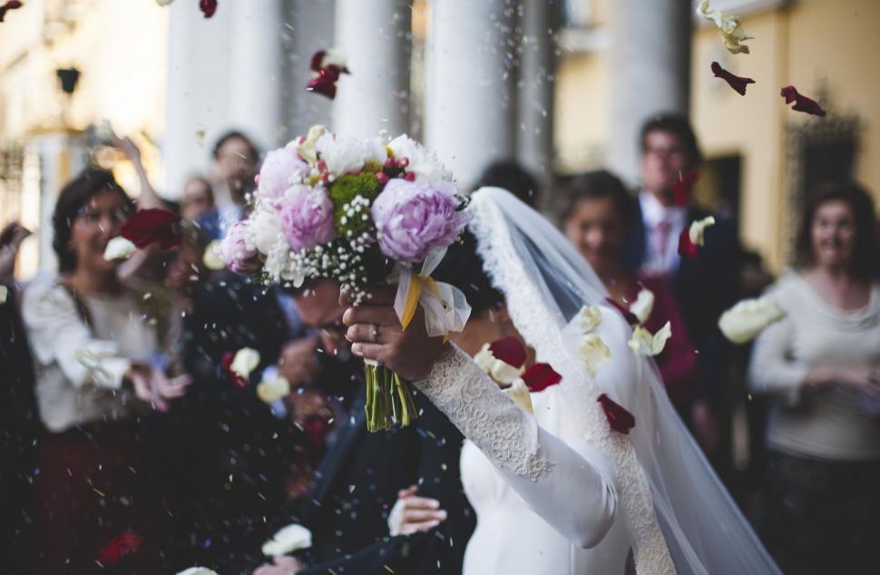 Free Image of Woman in Wedding Dress Holding Bouquet of Flowers 
