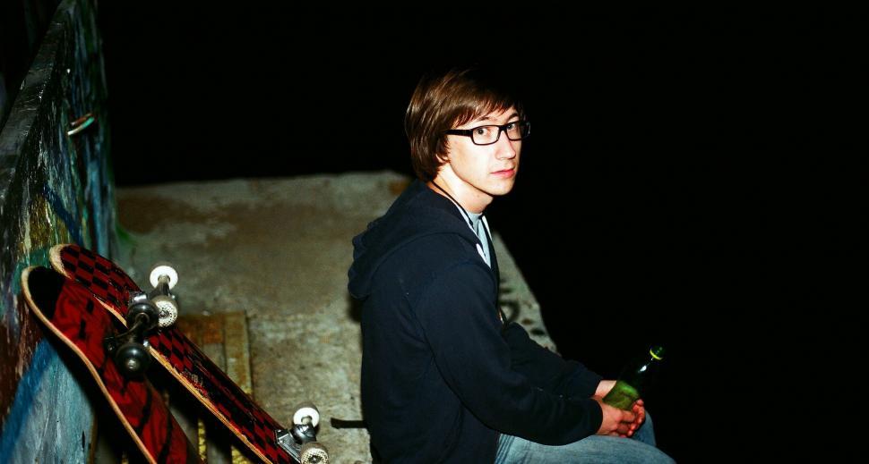 Free Image of Man Sitting on Wall With Skateboard 